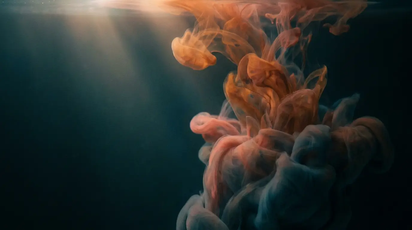 Amber and coral pigment dispersing into teal water